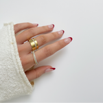 Hand wearing two rings on a white background