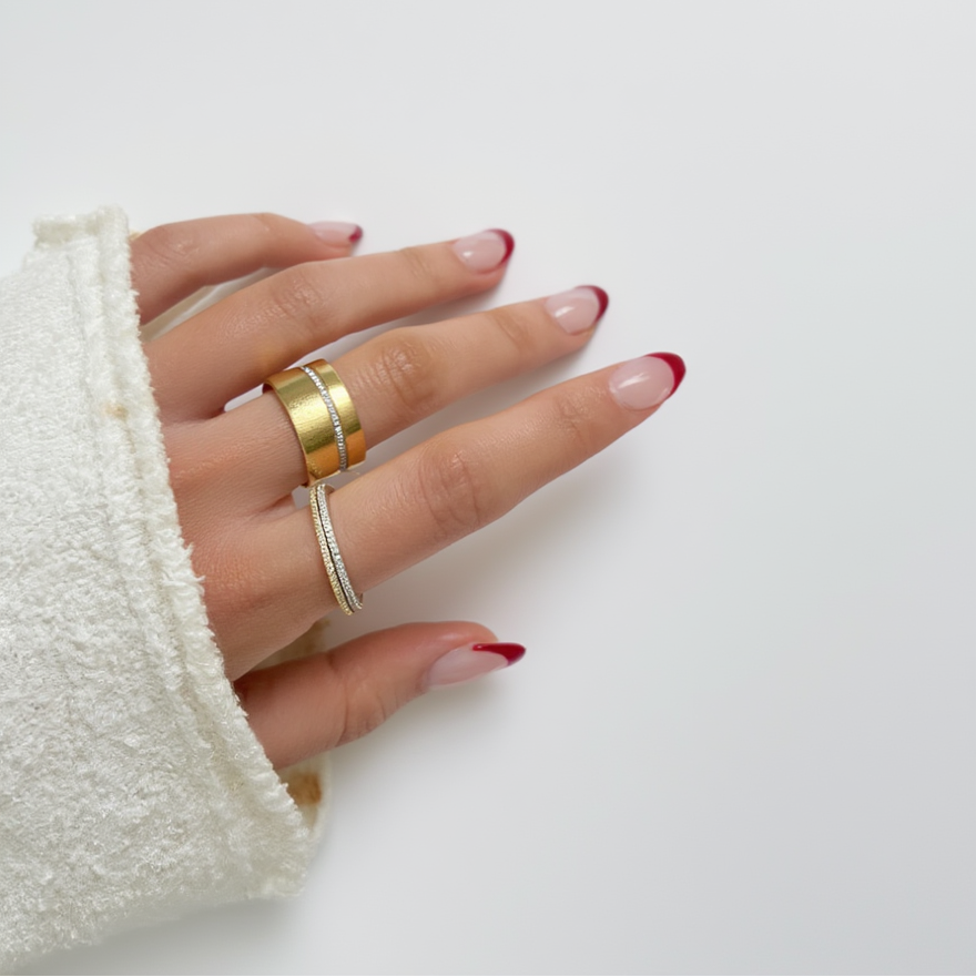 Hand wearing two rings on a white background