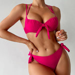 Person wearing a bright pink bikini against a plain background