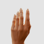 Hand with a ring on a blurred natural background