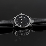 Black wristwatch with a reflective surface on a dark background