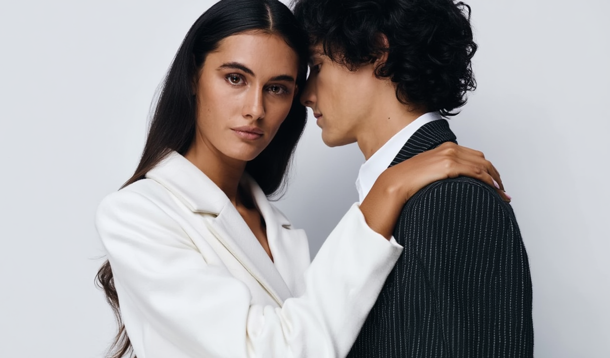 Two people in formal attire against a plain background